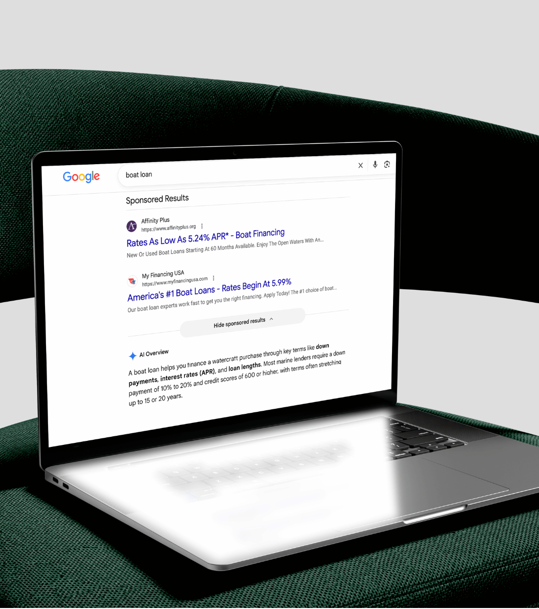 laptop sits on green chair showing paid search results