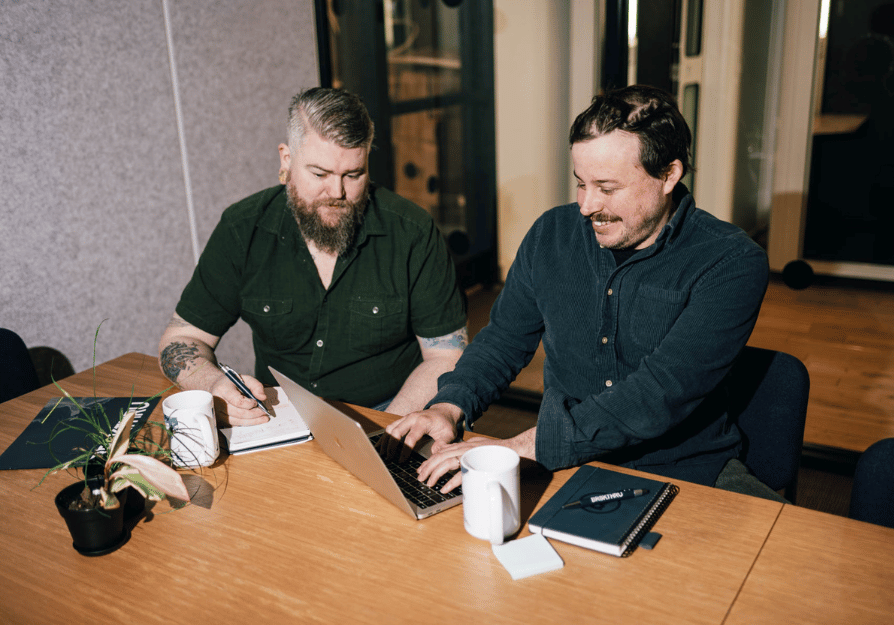 two men in work meeting looking at laptop