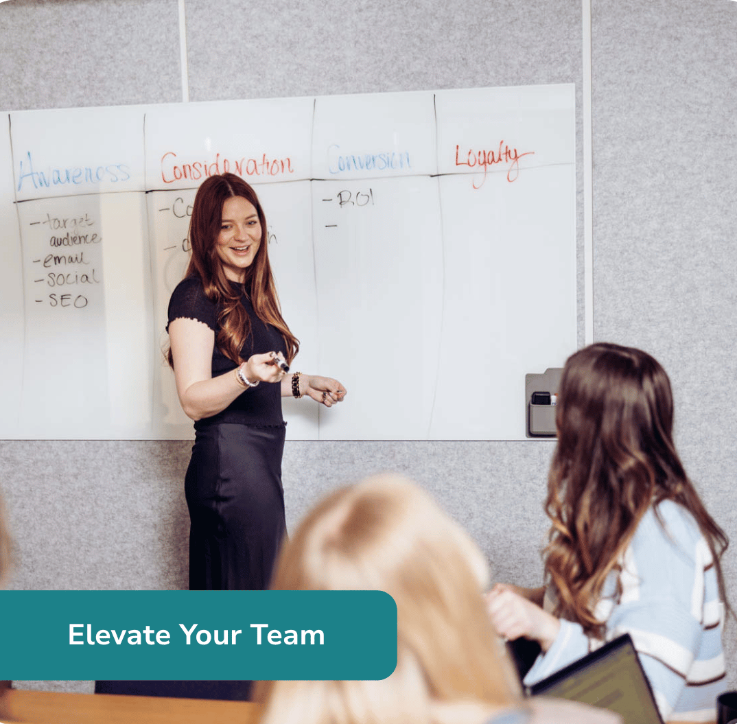 woman leads a meeting in front of a whiteboard